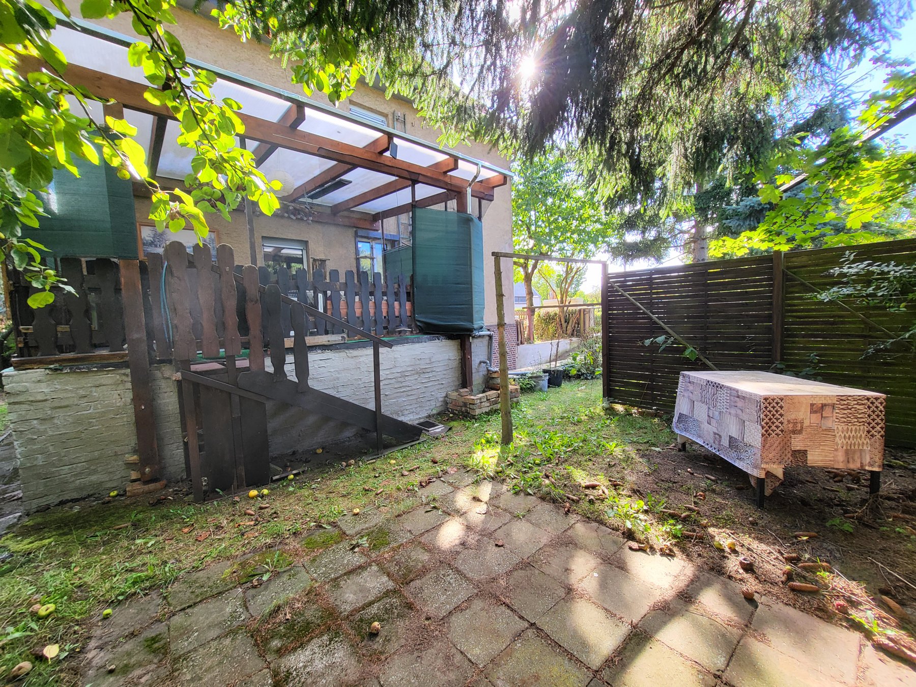 Blick aus dem Garten zur überdachten Terrasse der EG-Wohnung